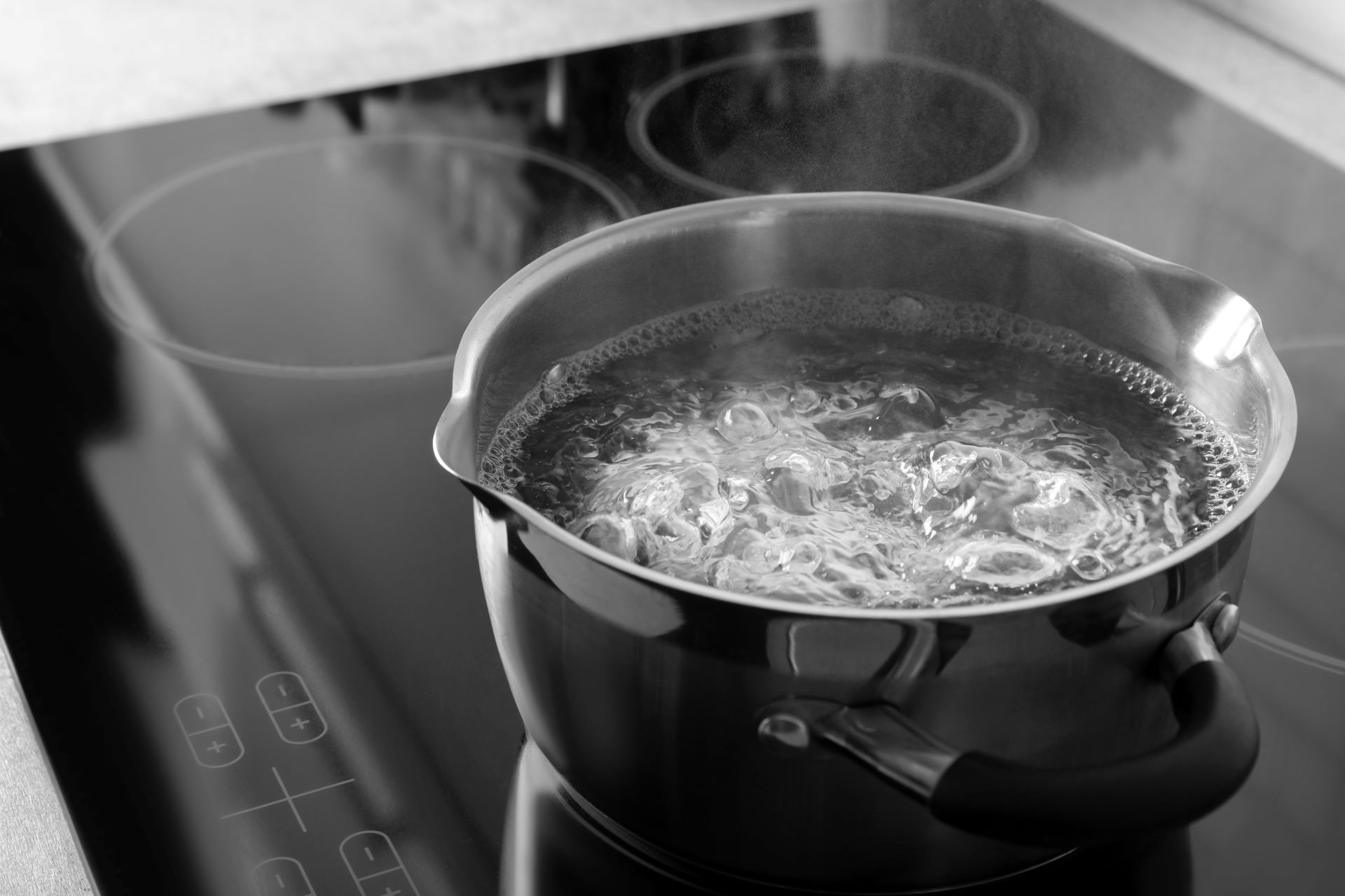 Kochtopf mit sprudelndem Wasser auf Induktionsherd