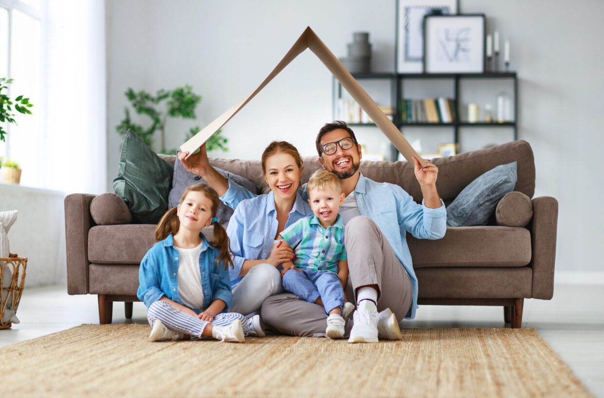 Familie mit Kindern in harmonischem Wohnzimmer | Steinwand